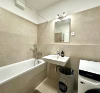 Fürdőszoba egy kétszobás lakásban káddal, mosdóval és mosógéppel.