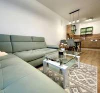 Nappali egy kétszobás lakásban, fa mintázatú padlóval és kényelmes kanapéval.