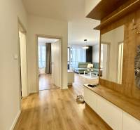 Folyosó egy 2 szobás lakásban fa dekor padlóval és beépített bútorokkal.