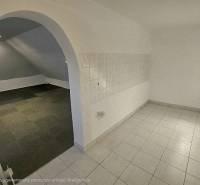 Üzlethelyiség belső tere boltíves átjáróval és kombinált padlóburkolattal.