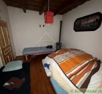 Szoba egy családi házban fa dekorációjú padlóval és egyszerű berendezéssel.