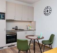 Konyha egy egyszobás lakásban, fa dekoros padlóval és étkezőasztallal.