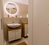 Fürdőszoba mosdóval és tükörrel, egyszobás lakás része.