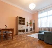 Nappali egy háromszobás lakásban fa dekor padlóval, kanapéval és bútorokkal.