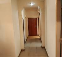 Keskeny belső folyosó kerámia padlóval egy kétszobás lakásban.