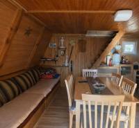 A faház belső tere fa burkolattal, lépcsőkkel és fa dekorációjú padlóval.