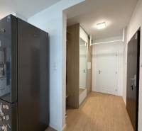 Konyha és előszoba egy háromszobás lakásban fa mintázatú padlóval.