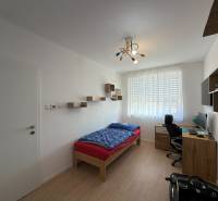 Gyerekszoba egy háromszobás lakásban, fa dekoros padlóval, íróasztallal, ággyal.