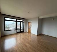 Szoba egy családi házban fa dekoros padlóval és nagy ablakokkal a kertre.