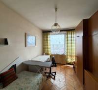 Szoba egy családi házban fa dekor padlóval, kanapéval és nagy szekrénnyel.