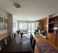 Nappali egy családi házban, fa dekoros padlóval, étkezőasztallal és kandallóval.