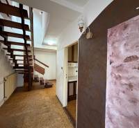 Folyosó nyitott lépcsőkkel egy családi házban, fa dekorációjú padlóval.