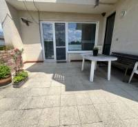 A Tálová utcai családi ház terasza Nagyőrvisen műanyag asztallal és virágokkal.