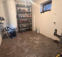 Családi ház raktárhelyisége polccal és sportfelszereléssel, fa dekorációjú padlóval.