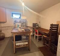 Családi ház konyhája egyszerű bútorokkal és élelmiszer-feldolgozó berendezésekkel.