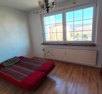 Hálószoba ággyal, szekrénnyel és fa dekorációjú padlóval egy kétszobás lakásban.