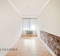 Keskeny szoba fa dekor padlóval, függönyös ablak, radiátor.