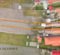 Családi ház Topoľníkyben kerttel, látható mezőgazdasági föld és épületek.