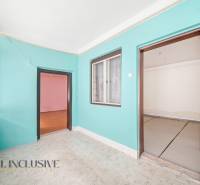 Szoba egy családi házban színes falakkal, laminált padlóval és nagy ablakkal.