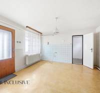 Családi ház belső tere fa mintázatú padlóval és fehér falakkal.