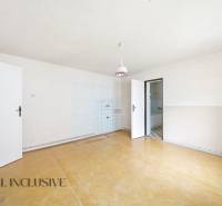 Tágas szoba egy családi házban, fa dekorációjú padlóval és egyszerű világítással.