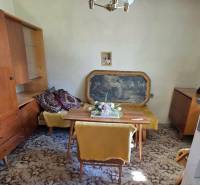 A családi ház ebédlője szőnyegpadlóval, bútorokkal és függő csillárral rendelkezik.