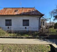 Családi ház Pavlovce nad Uhom-ban, fém kerítés, előkert, bádogtető, fa.