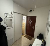 Előszoba egy 3 szobás lakásban fogasokkal, tükörrel és bejárati ajtóval.