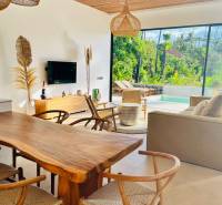 Családi ház fa mintázatú padlóval, fonott lámpákkal és kilátással a természetre.