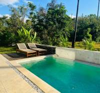 Családi ház medencéje Amedében, zölddel és kék éggel körülvéve.