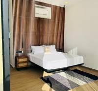 Hálószoba családi házban mintás fallal, ventilátorral, szőnyeggel és fa dekorációjú padlóval.