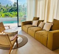 Családi ház nappalija nagy ablakkal, kilátással a kertre és a medencére.