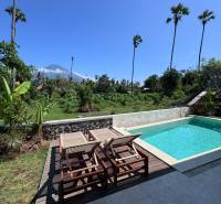 Napozóágyak és napozóágyak kilátással a zöldre az Amed utcában, Amed, egy családi ház mellett.