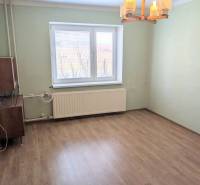 Szoba családi házban fa dekoros padlóval és ablakkal, radiátorral.