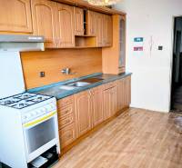 Konyha családi házban klasszikus konyhabútorral és fa mintázatú padlóval.