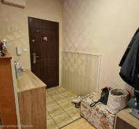 Előszoba egy háromszobás lakásban kőburkolattal és tárolóhelyekkel.