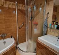 Fürdőszoba egy háromszobás lakásban káddal, zuhanyzóval és mosdóval.