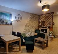 Nappali fa dekor padlóval és stílusos ülőgarnitúrával egy háromszobás lakásban.