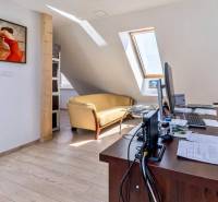 Irodák kanapéval, képpel a falon és fa dekorációjú padlóval.