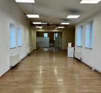 Irodák belső tere fa dekor padlóval és függő lámpákkal.