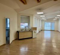 Irodák fa dekor padlóval, nagy ablakokkal és konyhasarokkal.