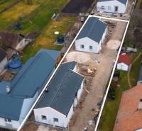 Családi házak építése Borcsicén, kertekkel és szomszédos házakkal körülvéve.