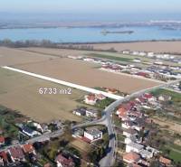 Lakóterületek Sokolovce-ban, a környező táj vízfelülettel a háttérben.