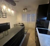 Konyha egy kétszobás lakásban üveglámpákkal és fa dekorációjú padlóval.