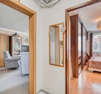 Egy 4 szobás lakás belső tere fa dekor padlóval, bútorokkal és tükörrel.