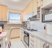 Konyha egy 4 szobás lakásban, gyümölcsökkel az asztalon és beépített készülékekkel.