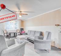 Nappali egy 4 szobás lakásban kényelmes fotelekkel és étkező sarokkal.