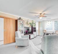 Világos nappali kanapékkal egy 4 szobás lakásban, fa mintázatú padlóval.