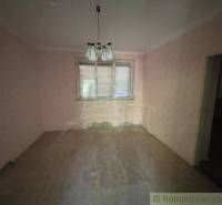 Szoba egy családi házban rózsaszín falakkal és fa dekorációjú padlóval.