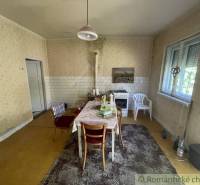 Családi ház étkezője konyhaasztallal és szőnyeggel, klasszikus hangulat.